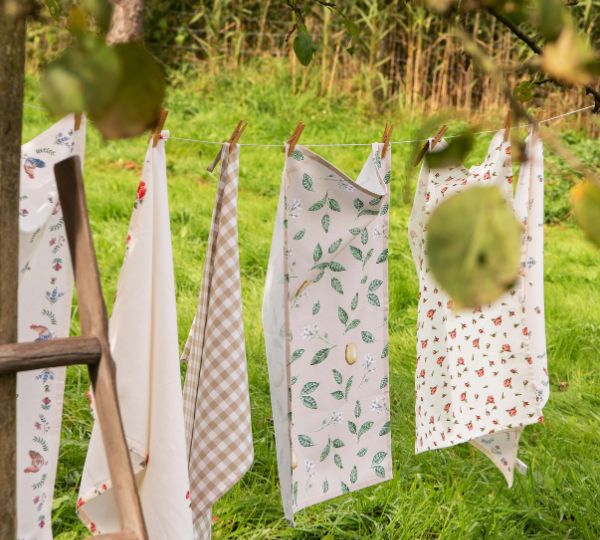 Kitchen textiles hanging on a line outdoors.