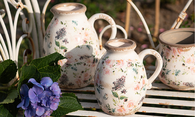 Two romantic vases covered with antique roses and lavender, and next to them lies a purple hydrangea